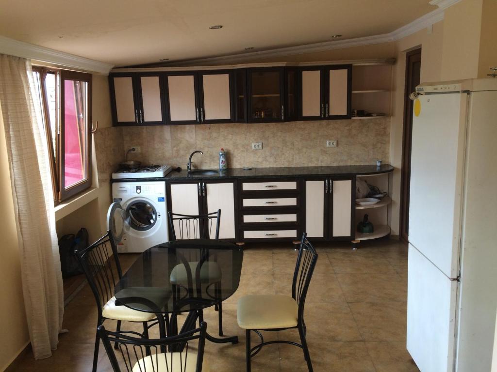 a kitchen with a table and chairs and a sink at Guesthouse Gorgasali 57 in Batumi