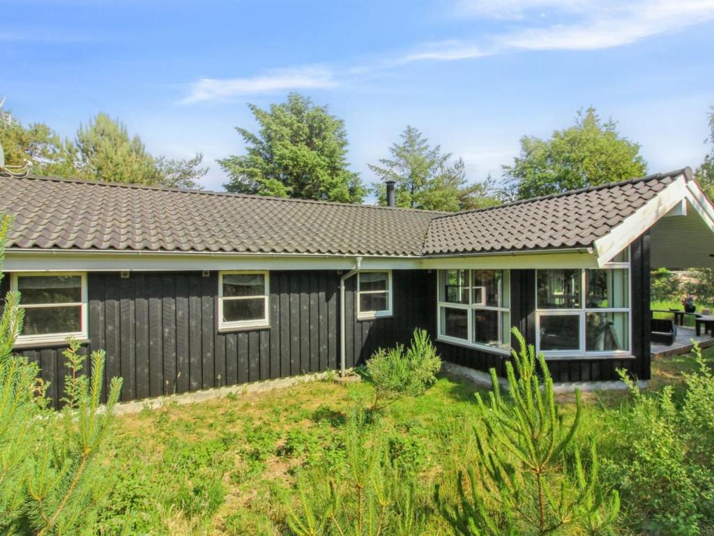 Ein Haus mit einem schwarzen Haus in der Unterkunft Holiday Home Arlett - 950m from the sea in NW Jutland by Interhome in Fjerritslev