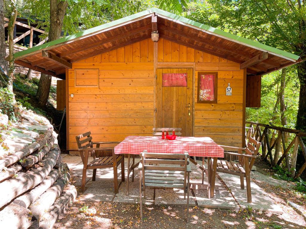 una mesa y sillas frente a una cabaña en Le sorgenti - Chalet 57, en Palazzuolo sul Senio