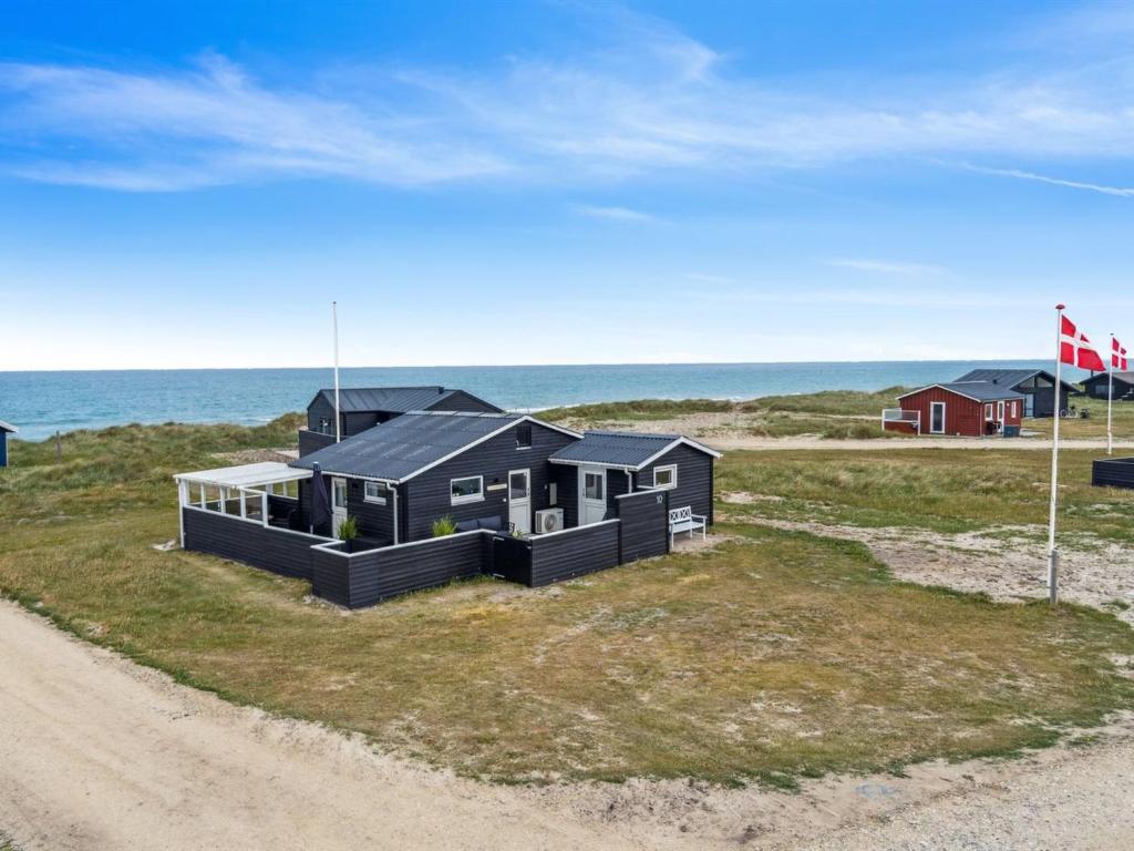 uma casa negra na praia perto do oceano em Holiday Home Rieke - 40m from the sea in NW Jutland by Interhome em Hjørring