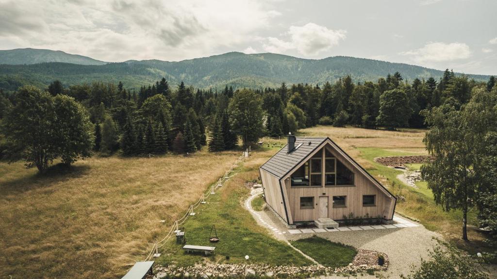 eine Aussicht auf ein kleines Haus auf einem Feld in der Unterkunft Slow Life Pod Babią Górą in Zawoja