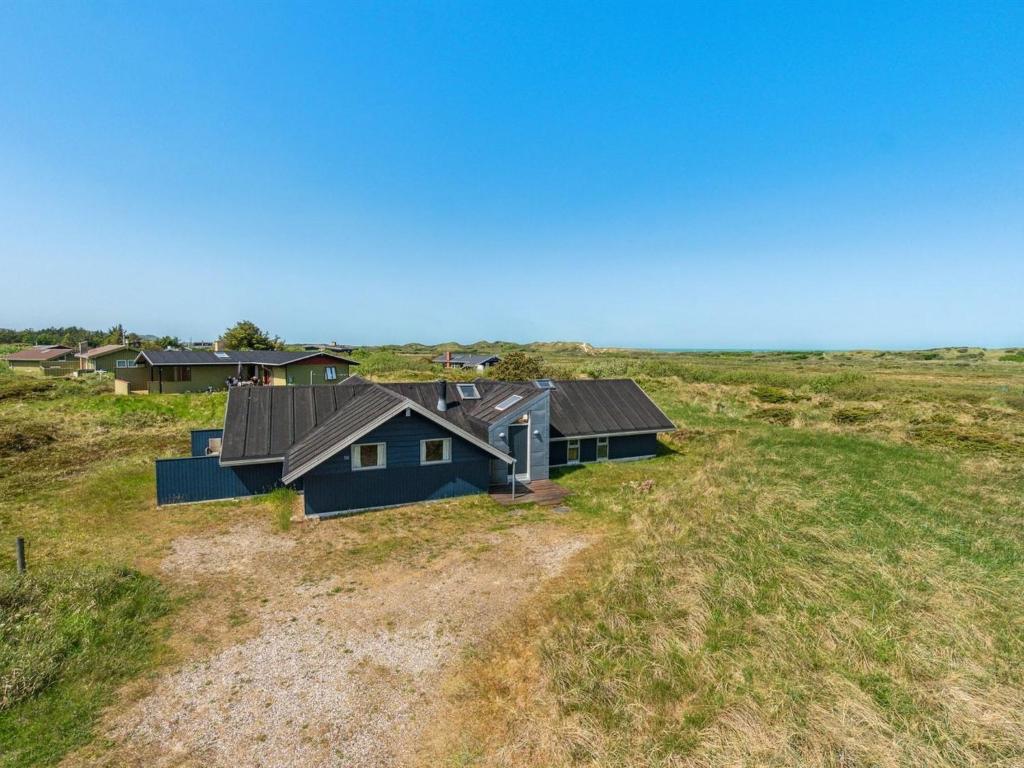 ein blaues Haus mitten auf einem Feld in der Unterkunft Holiday Home Henri - 500m from the sea in NW Jutland by Interhome in Fjerritslev