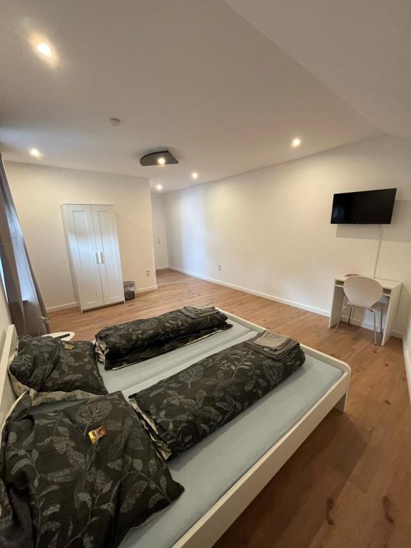 2 Betten in einem Zimmer mit einem TV an der Wand in der Unterkunft Übernachtung by Tag in Staufenberg