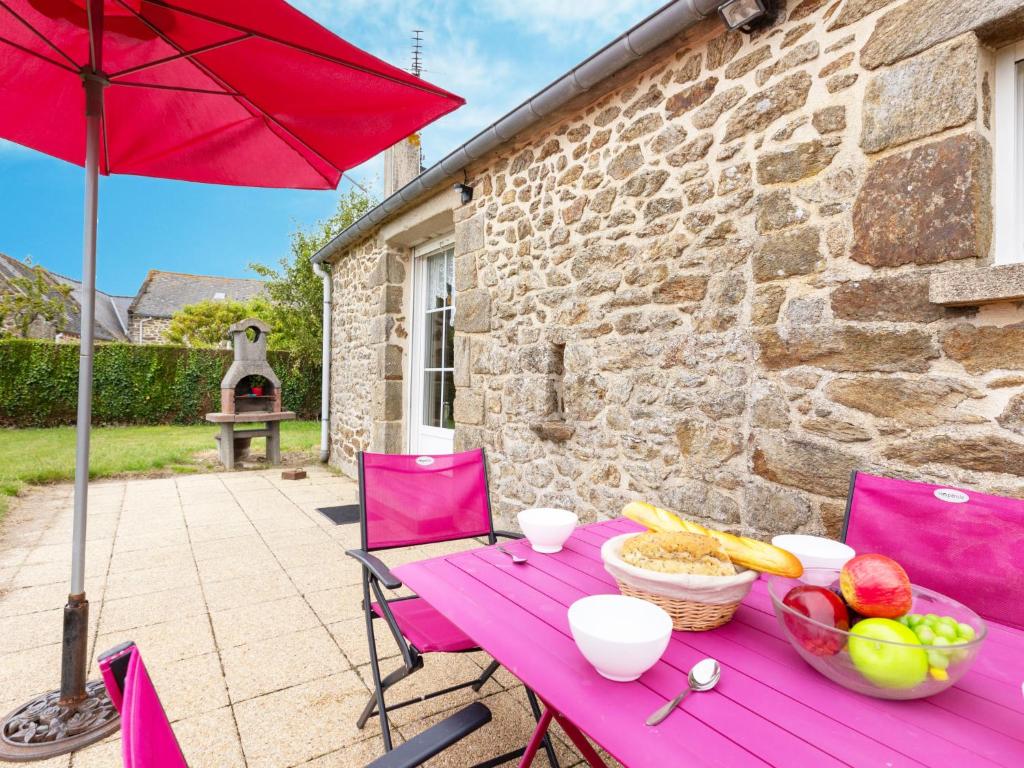 een paarse tafel met fruit en een rode paraplu bij Holiday Home opale by Interhome in Saint-Coulomb