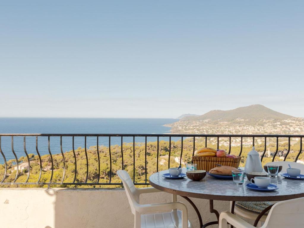 a table on a balcony with a view of the ocean at Apartment Chantelyre-1 by Interhome in Carqueiranne