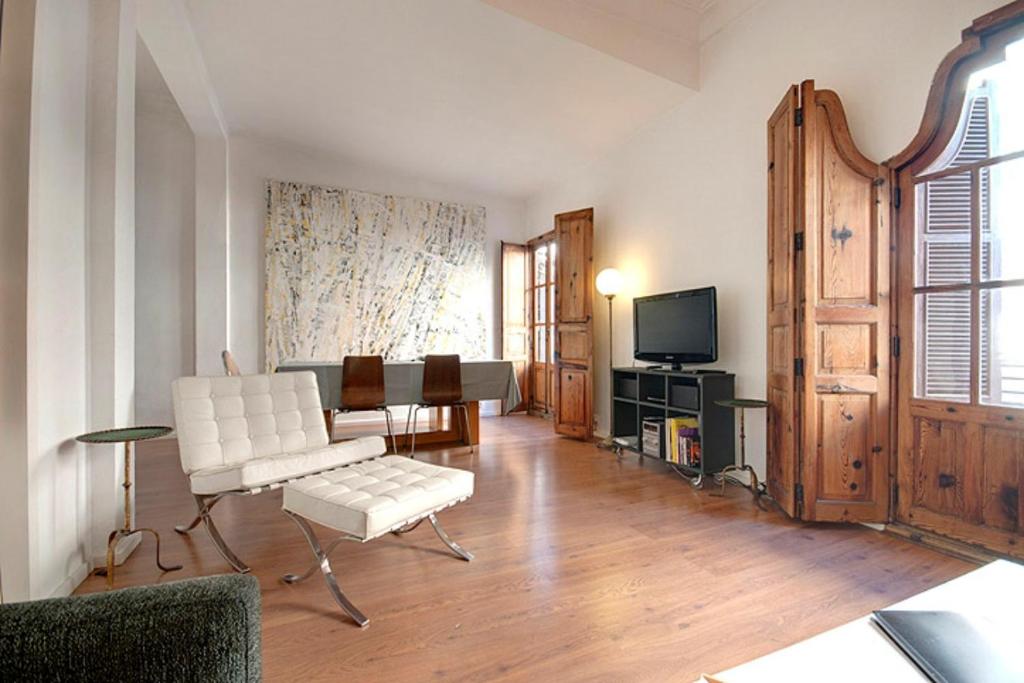 sala de estar con muebles blancos y TV en Beds & Breaks Strauss, en Valencia