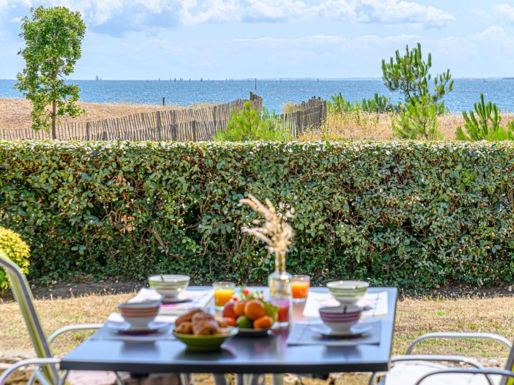 a table with fruit on it with the ocean in the background at Apartment Les Horizons-2 by Interhome in Carnac