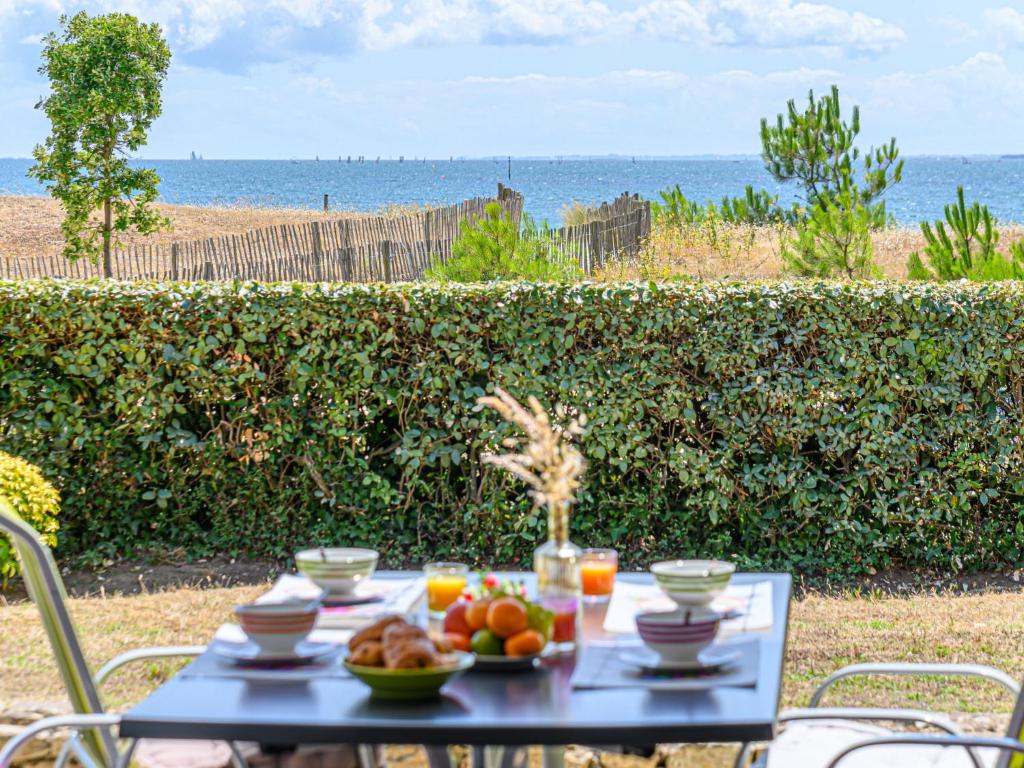 une table avec des fruits dessus avec l'océan en arrière-plan dans l'établissement Apartment Les Horizons-2 by Interhome, à Carnac