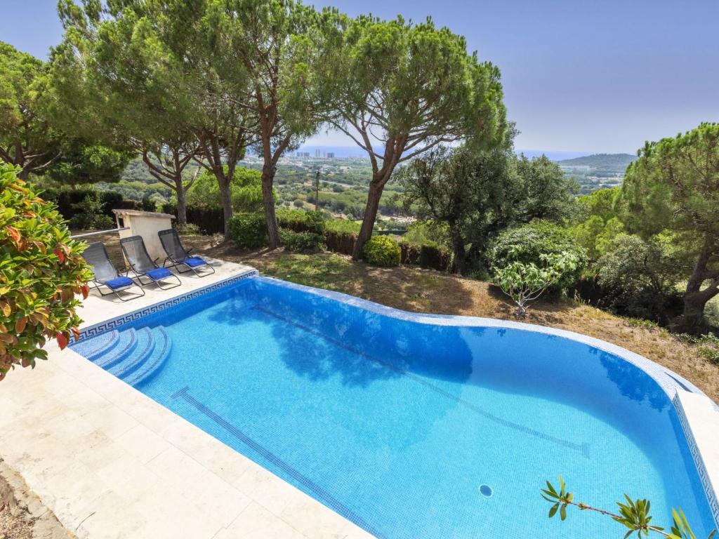 una grande piscina blu con sedie e alberi di Holiday Home Can Semi by Interhome a Platja  d'Aro