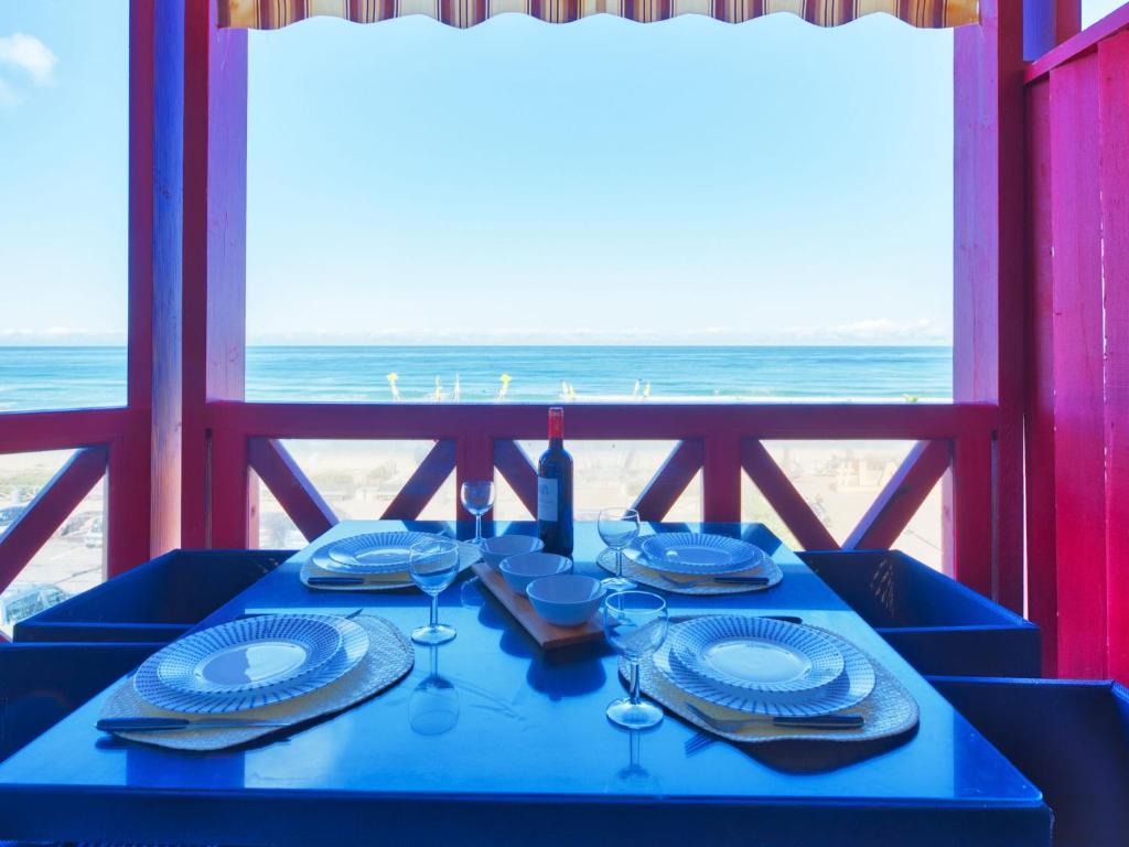 a blue table with plates and wine glasses on the beach at Apartment Primavéra-12 by Interhome in Lacanau-Océan