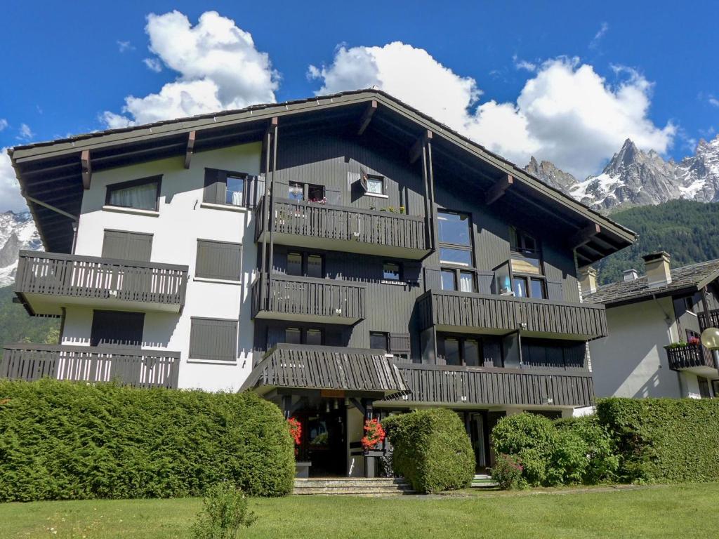 un grand bâtiment blanc avec des balcons et une montagne dans l'établissement Apartment Champraz-17 by Interhome, à Chamonix-Mont-Blanc