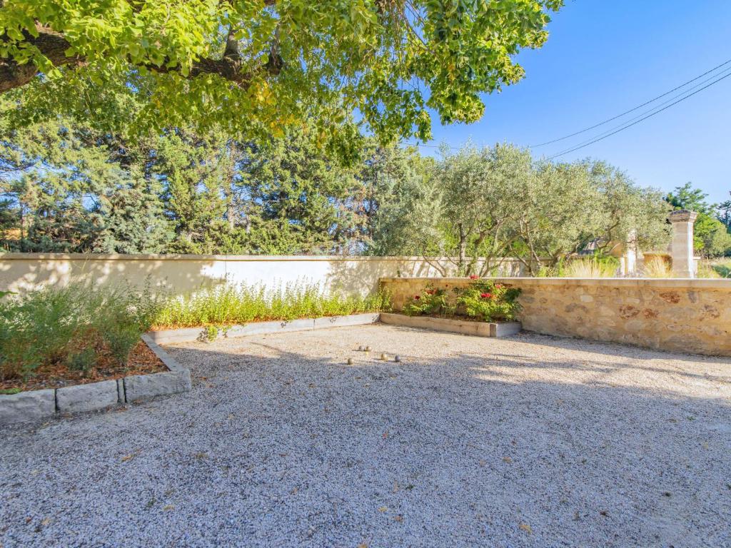 a backyard with a stone wall and a garden at Holiday Home Le Mas de Marius by Interhome in Cavaillon