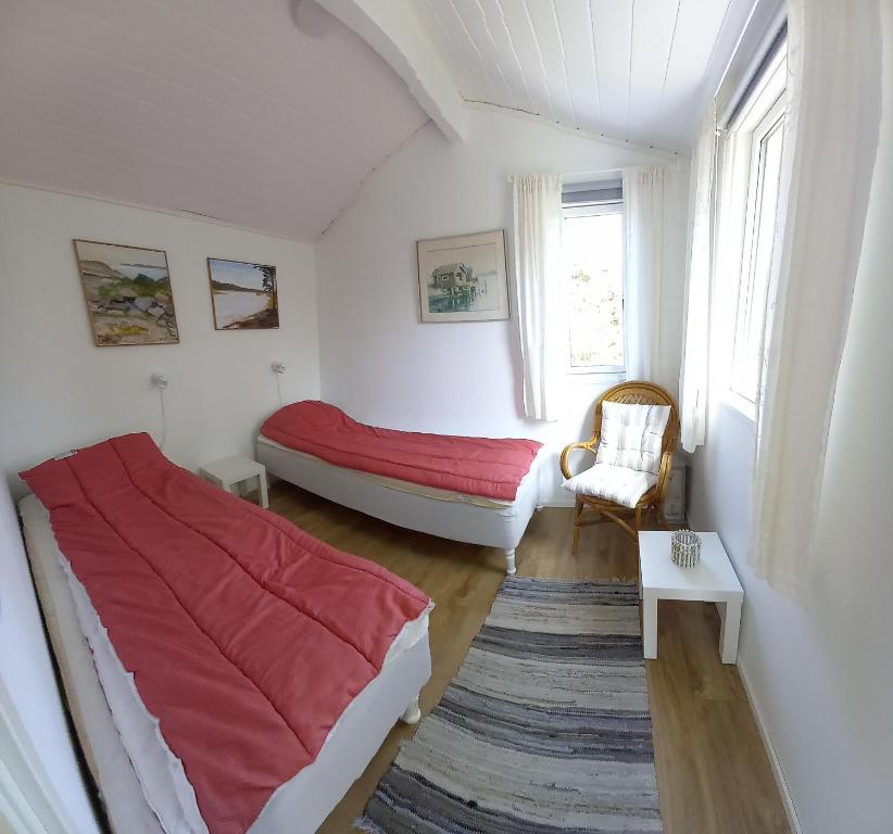Tofte Guesthouse nära hav, bad och Marstrand في Lycke: غرفة نوم بسرير واريكة وكرسي