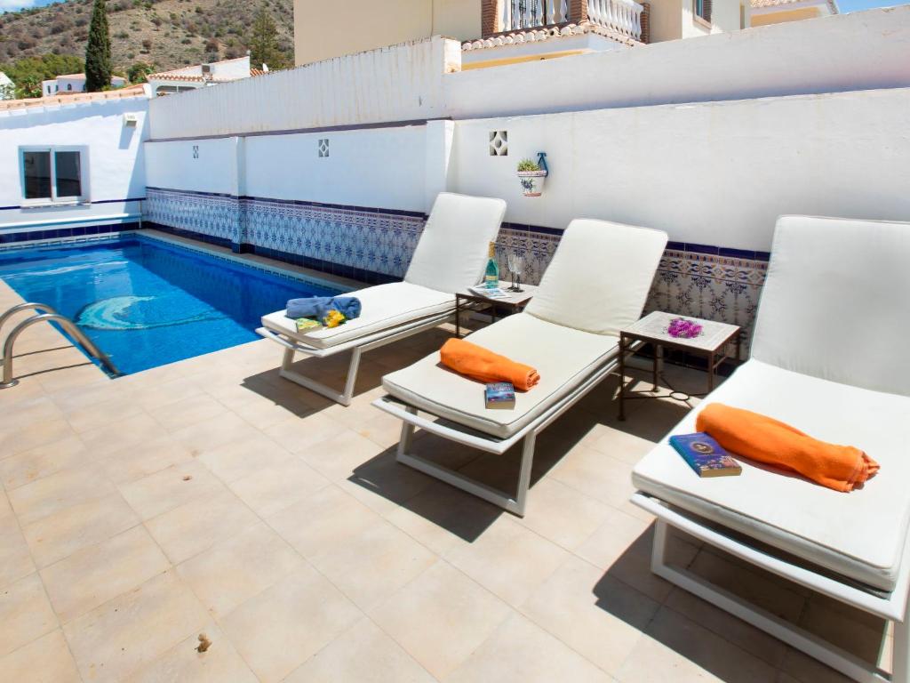 a patio with chairs and a swimming pool at Villa Helene by Interhome in Nerja