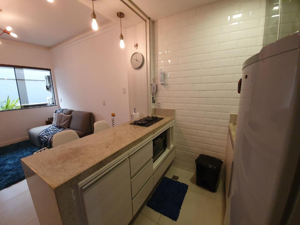 a kitchen with a counter and a living room at Pier Sul Apartaments in Salvador