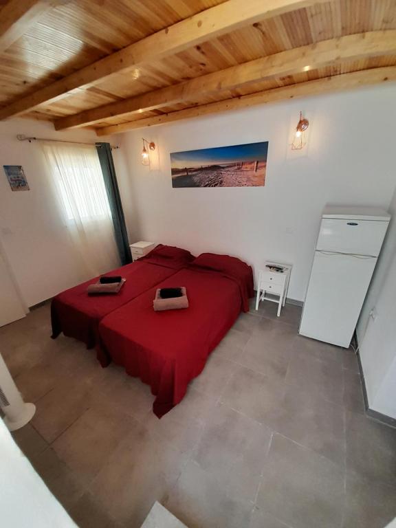 ein Schlafzimmer mit einem roten Bett in einem Zimmer in der Unterkunft Ibiza Suite Independent bedroom and bathroom in Albufeira