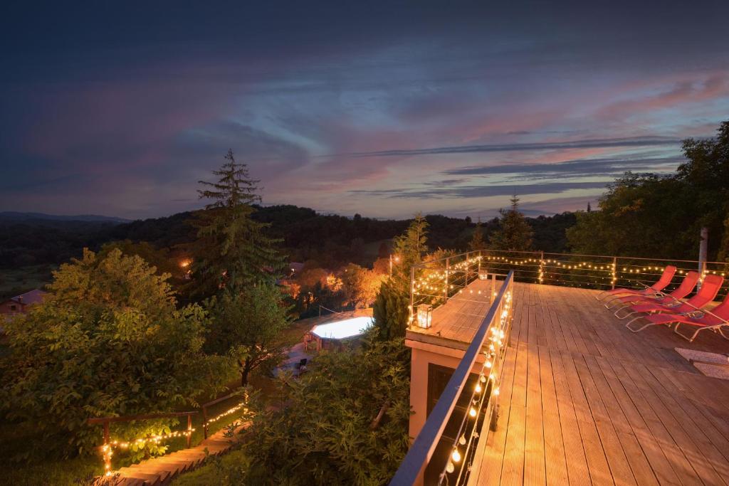 una terraza con sillas y luces por la noche en Beautiful Villa Pool and magic sunsets Croatia, en Kuzminec