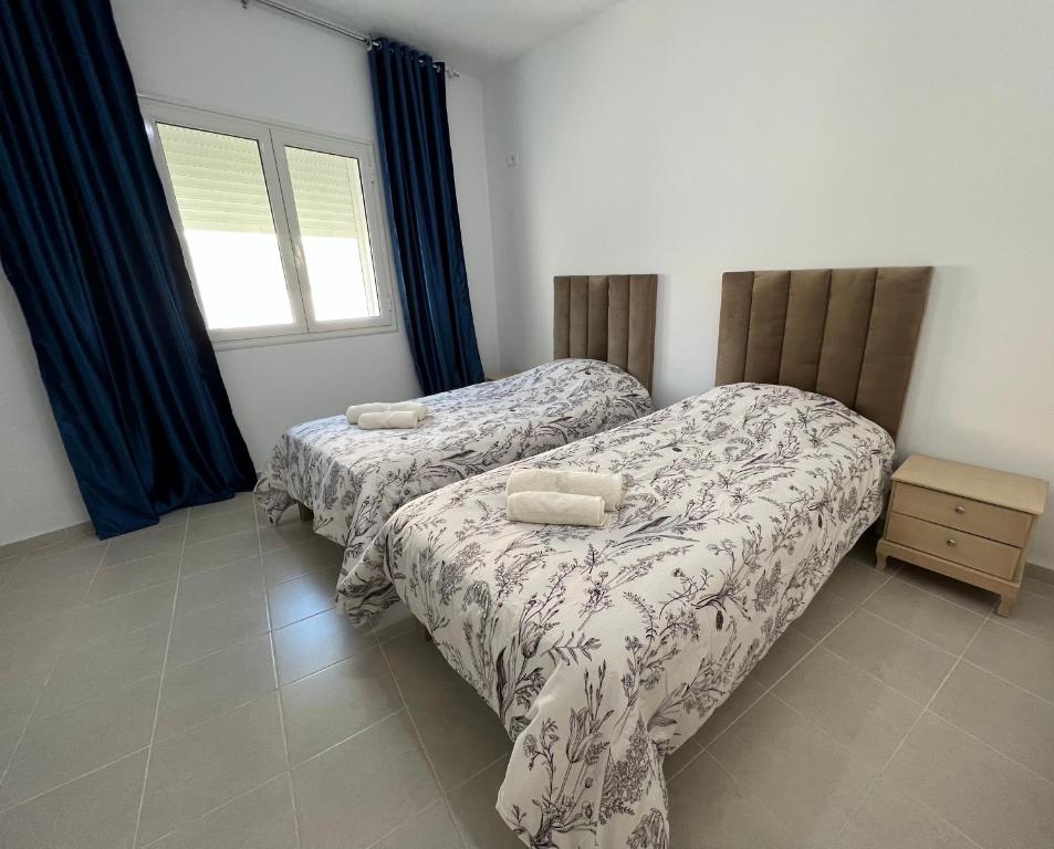 a bedroom with two beds and a window at EVA'S HOME in Bizerte