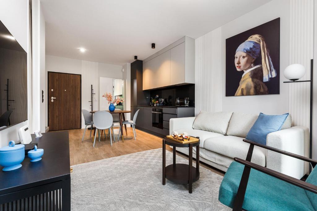 uma sala de estar com um sofá branco e uma cozinha em Scala Apartments by HappyStay em Gdansk