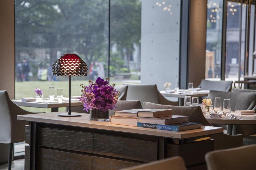 a table in a restaurant with books and flowers on it at Eslite Hotel in Taipei