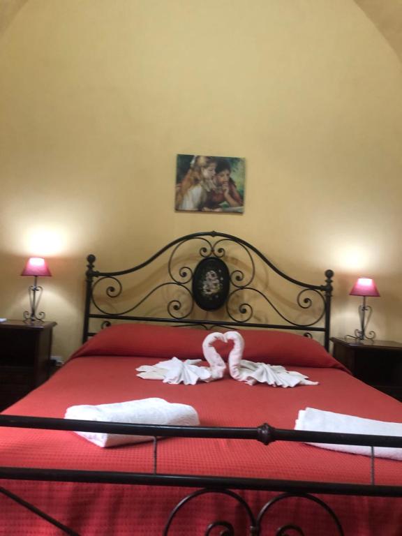 カターニアにあるCasa Benedettini tourist apartment in Sicilyのベッドルーム1室(赤いベッド1台、タオル2枚付)