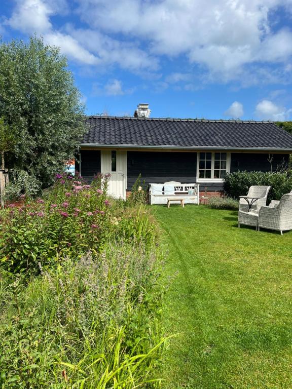 una casa con dos sillas en un patio en Het Buitenleven en Spaarndam