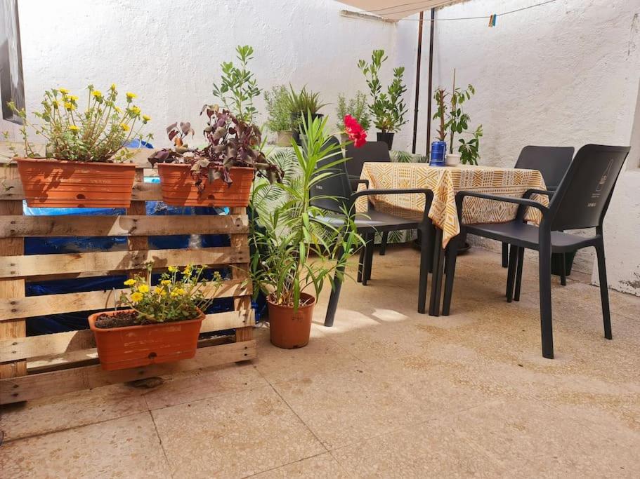 un patio con mesa, sillas y macetas en Estancia de Ensueño y Relax Parking Gratuito en Granada