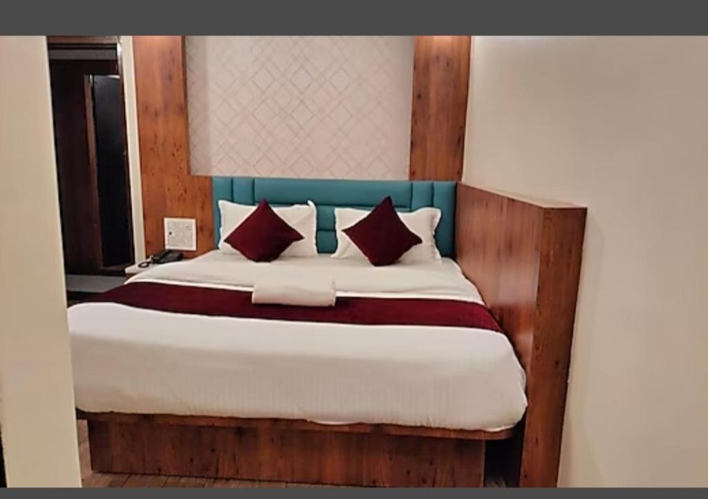 a bedroom with a large bed with red pillows at HOTEL DAISY in Guwahati