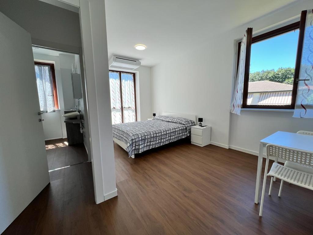 - une chambre avec un lit, une table et des fenêtres dans l'établissement Kibilù - Malpensa Airport - Easy check-in and check-out, à Cardano al Campo