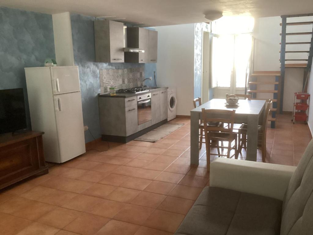 a kitchen and living room with a table and a refrigerator at Capricornio Club Diffuso in Maiori