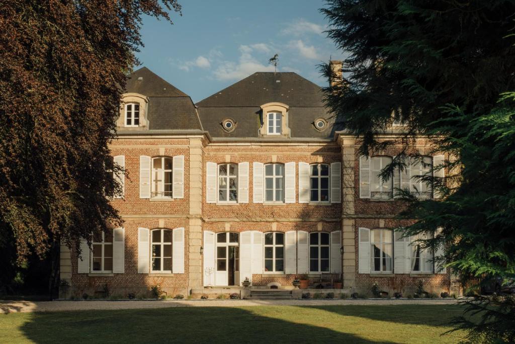 Vercourt的住宿－Petit Chateau Vercourt，一座大型砖砌建筑,设有白色门窗