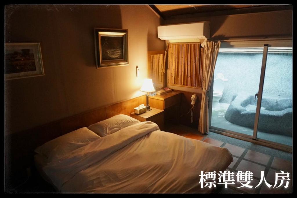 a bedroom with a bed and a window at 愛上龍過脈民宿 in Ch'u-lu