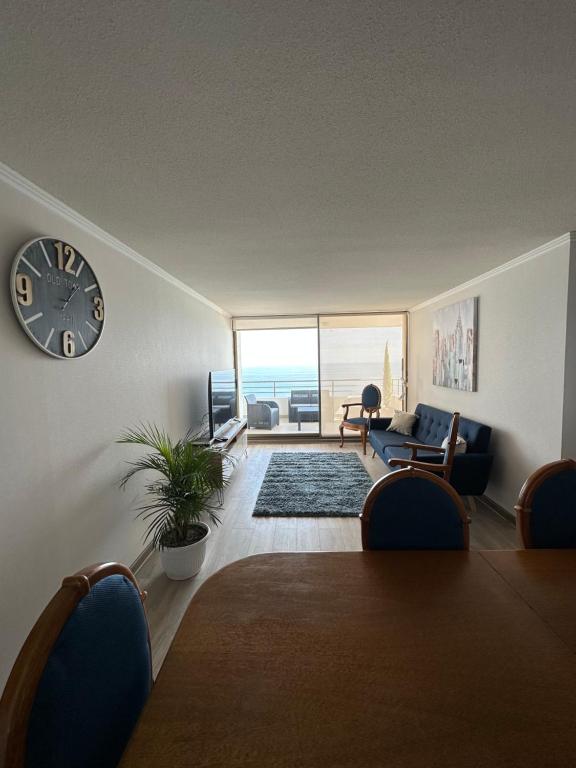 uma sala de estar com um relógio na parede em Departamento 3D2B Condominio Altos de Huayquique em Iquique