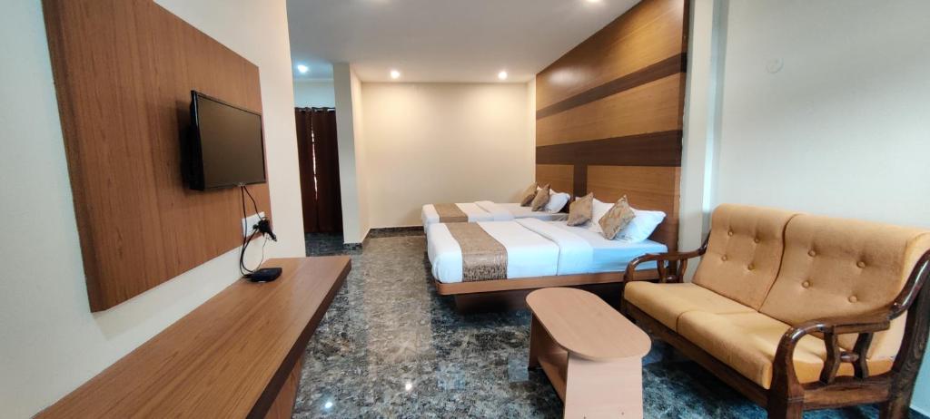 a hotel room with a bed and a couch at Sanjose Residency in Virajpet