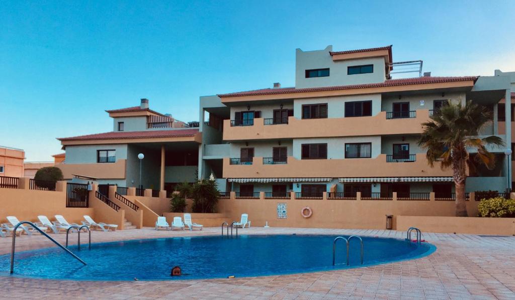 un hotel con piscina frente a un edificio en Apartamento La Marquesa Beach, en Puertito de Güímar