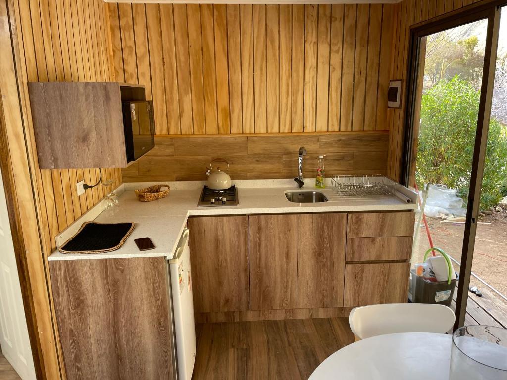 a small kitchen with a sink and a stove at Refugios Pisco Elqui in Pisco Elqui