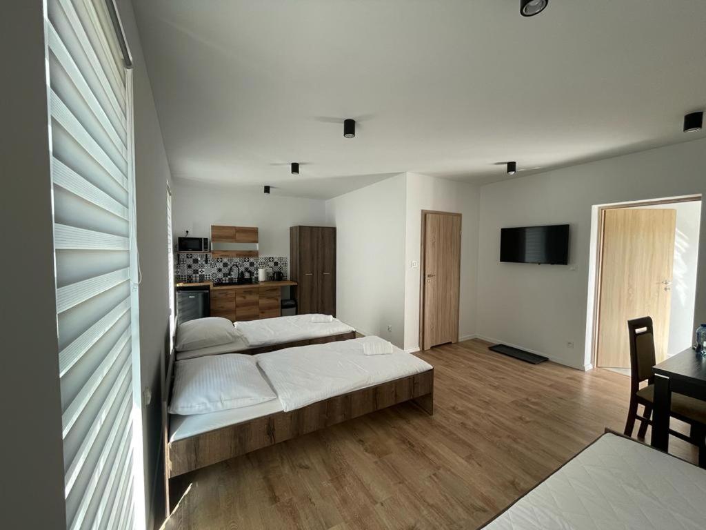 a bedroom with two beds and a kitchen with a table at Noclegi u Anny in Rzemień