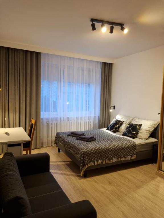 - une chambre avec un lit et un canapé dans l'établissement Apartament 51, à Gdynia