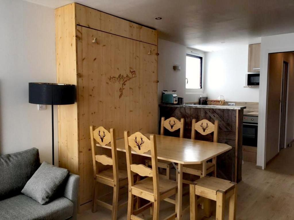 a kitchen with a table and chairs in a room at Studio Pour 4 Personnes in Chamrousse