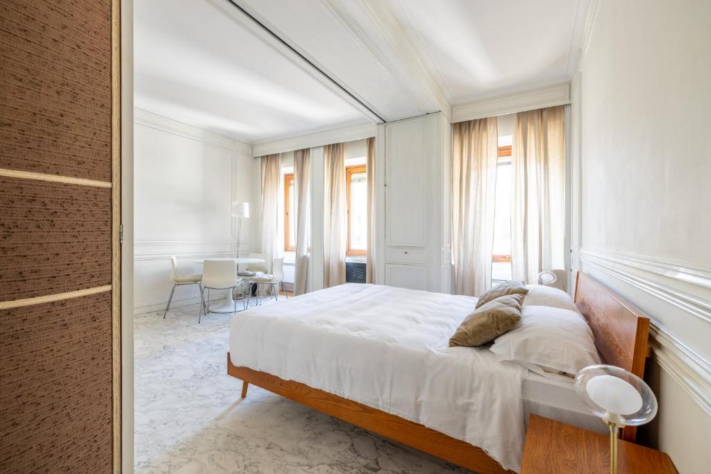 a white bedroom with a bed and a table at White Suite in Rome in Rome