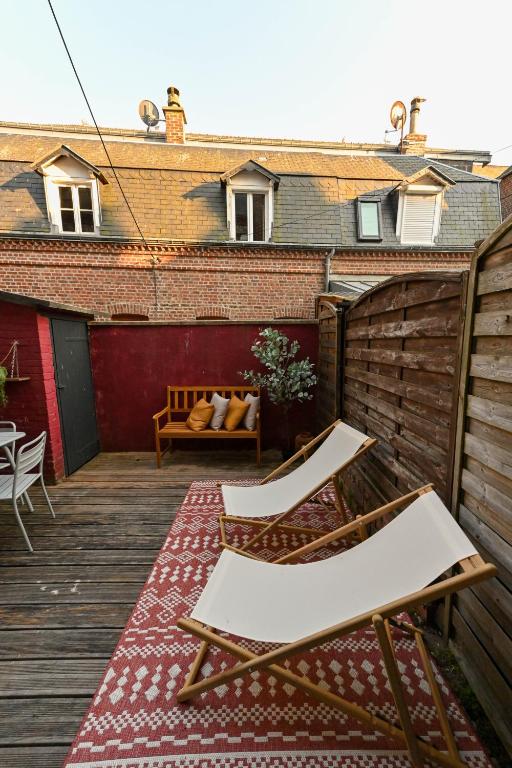 a patio with two chairs and a bench on a deck at LA DAME Avec TERRASSE- ETRETAT in Étretat