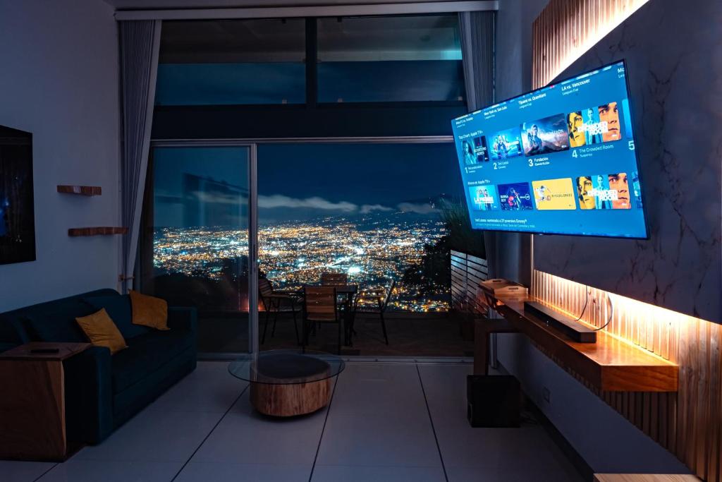 una persona che tiene una TV in soggiorno con vista di Apartamento Vista del Valle en San Antonio de Escazu 