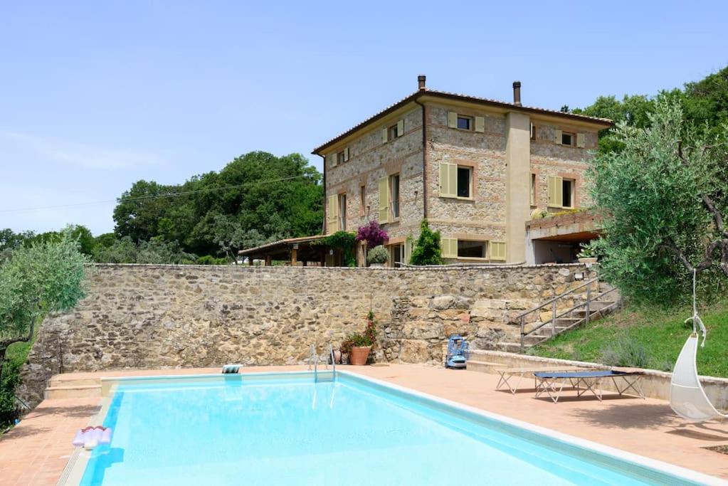 una casa con piscina frente a un edificio en Villa Fontelinda, en Scansano