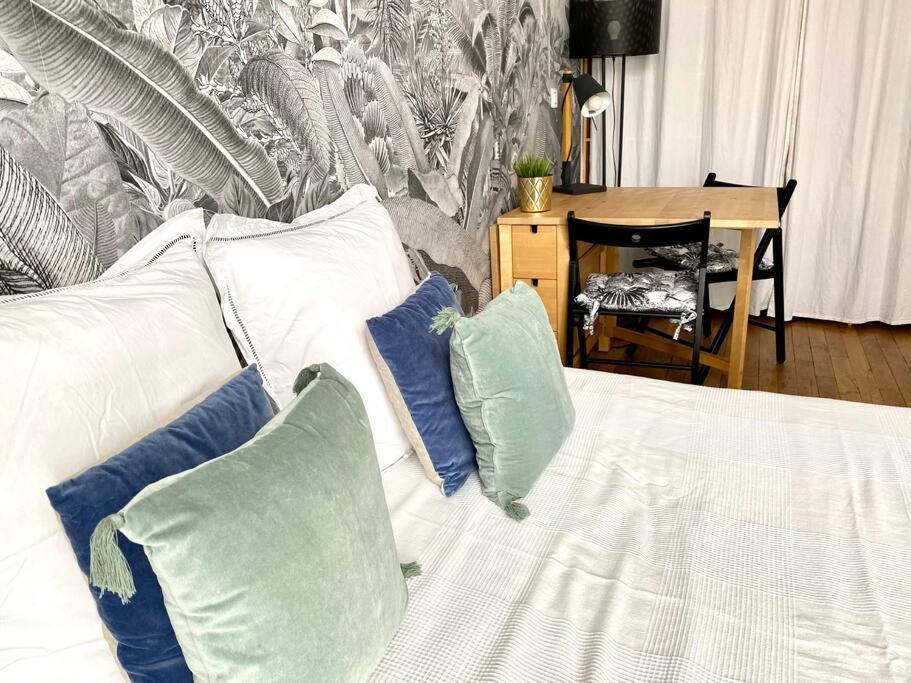 - un canapé blanc avec des oreillers et une table dans l'établissement Cozy studio near Montmartre, à Paris