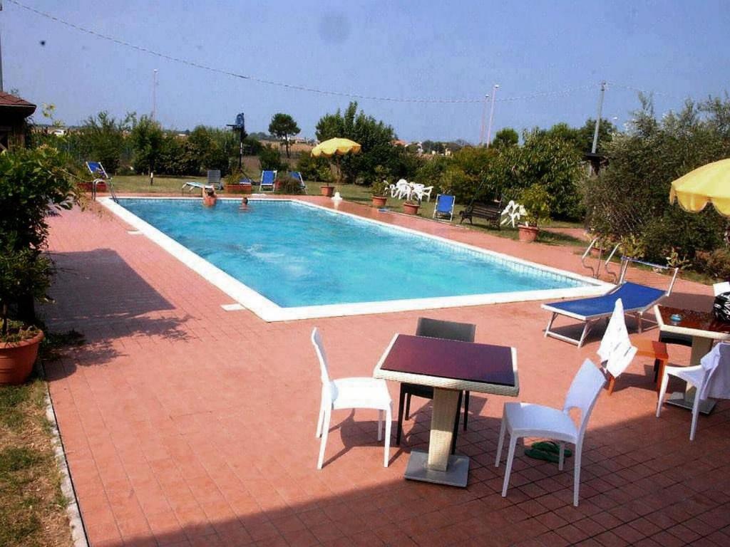 a swimming pool with chairs and a table and a table and chairs at Little Star pioppa in Riondi