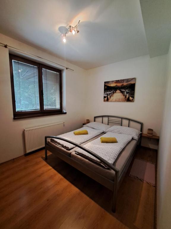 a bedroom with a bed with two yellow pillows on it at Apartmán Severanka in Vysoké Tatry