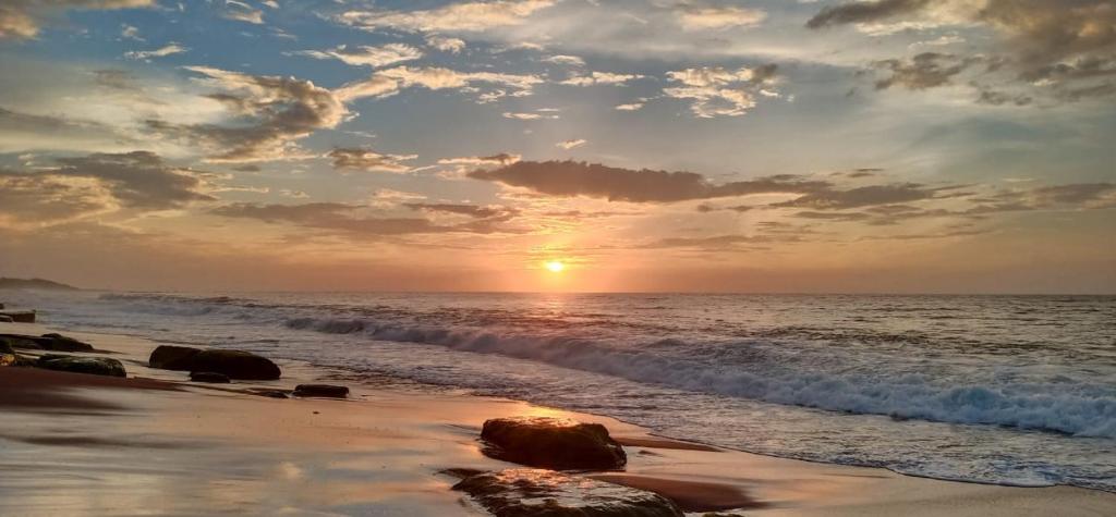 una puesta de sol en la playa con el océano en Luxury Beach Apartment, en Hambantota