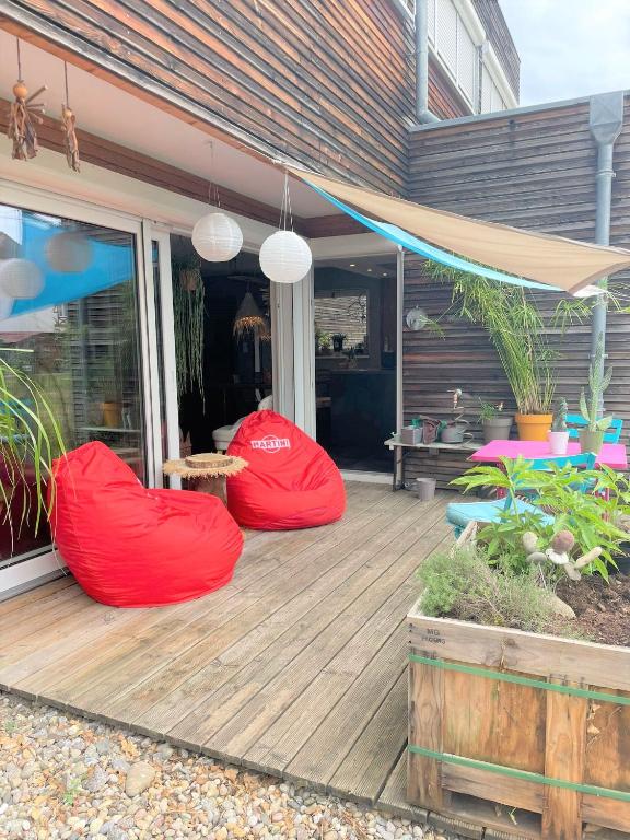 two red bean bags sitting on a wooden deck at A la villa du voyageur - proche Europa Park, Strasbourg et Colmar in Sélestat