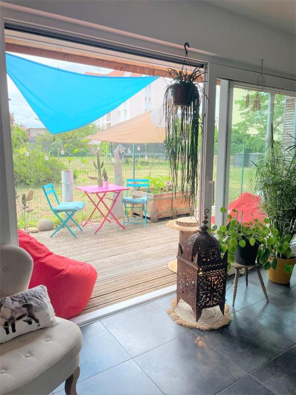 a living room with a patio with a table and chairs at A la villa du voyageur - proche Europa Park, Strasbourg et Colmar in Sélestat