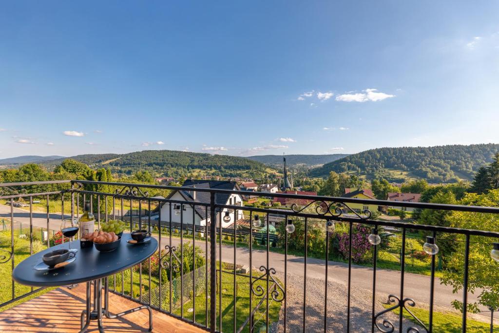 balkon ze stołem i widokiem na ulicę w obiekcie Villa Kasztelan w mieście Ustrzyki Dolne